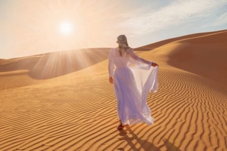 A girl is walking in the desert